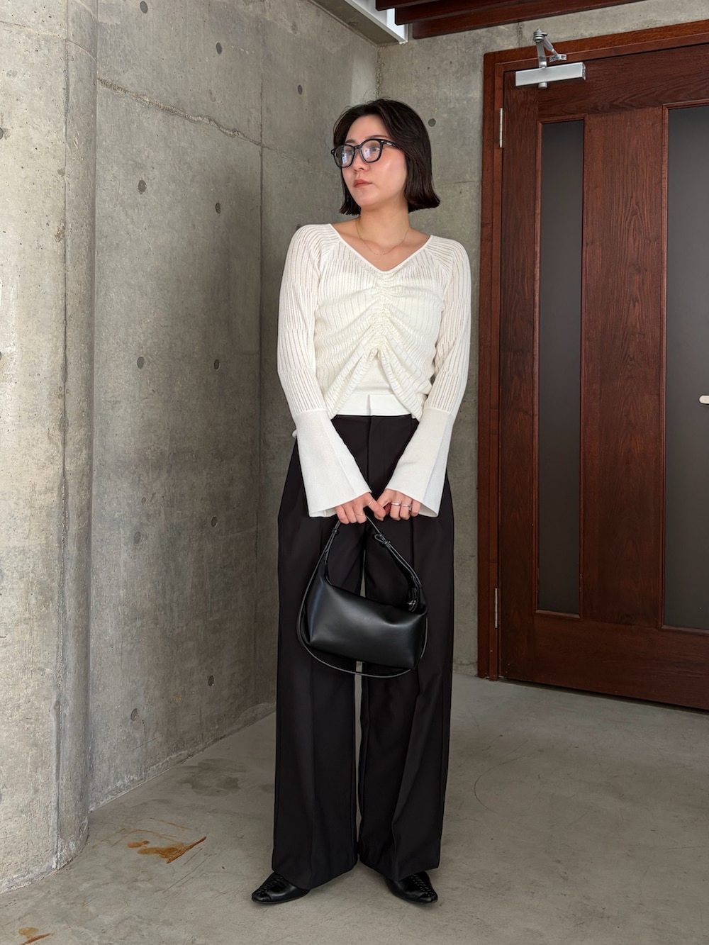 ホワイト系のニット/セーター、ホワイト系のその他パンツ、ブラック系のショルダーバッグを着用したレディースの春コーディネートの3枚目の写真