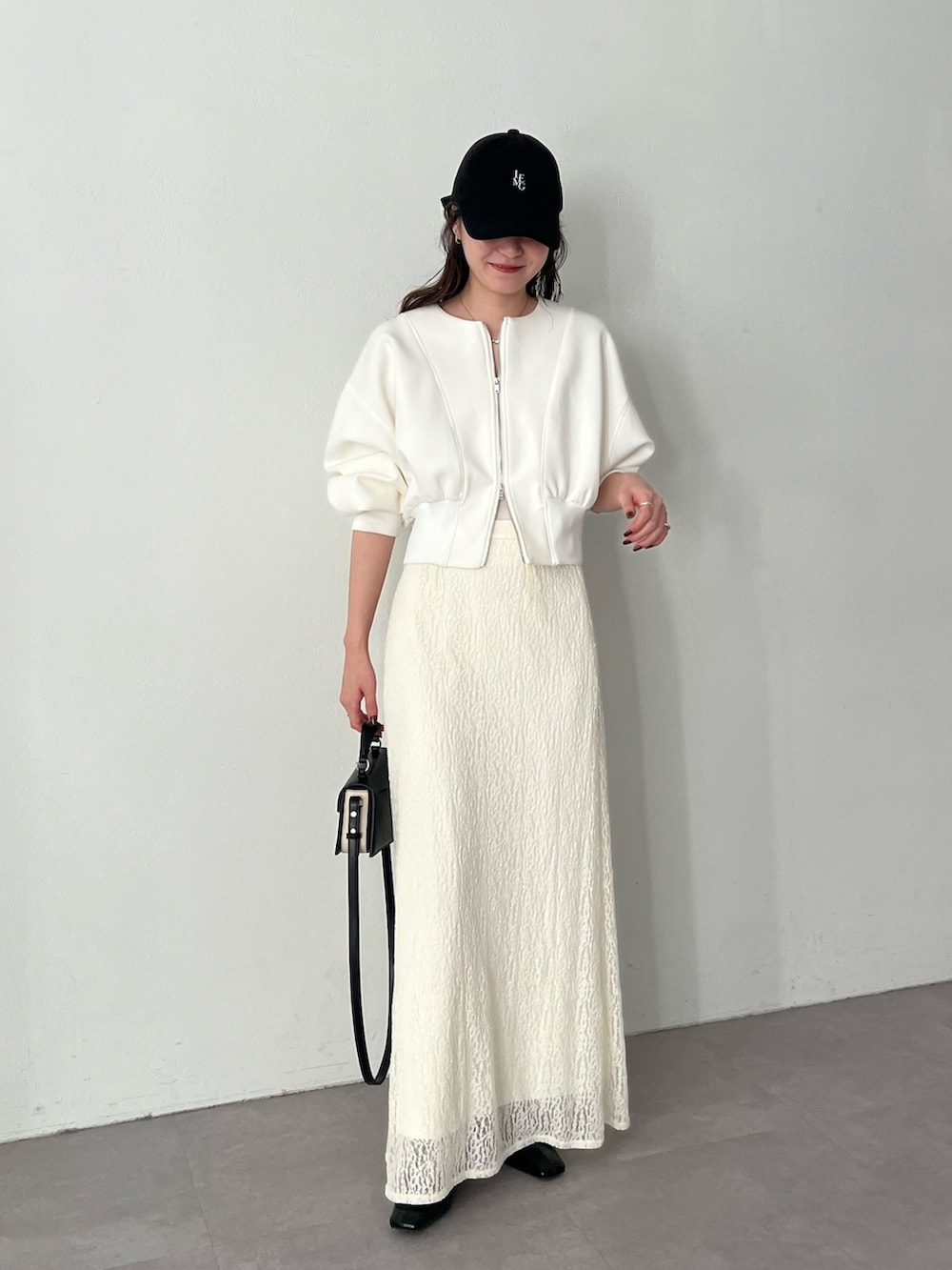 ホワイト系のスカート、ホワイト系のTシャツ/カットソーを着用したレディースの冬コーディネートの2枚目の写真