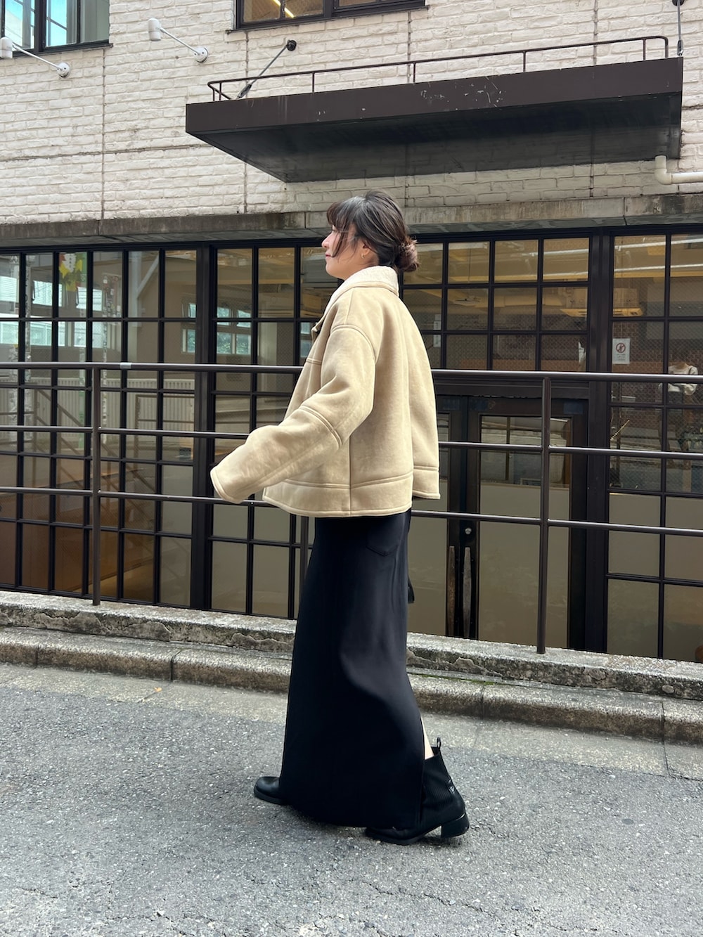 ブラック系のスカート、ホワイト系のTシャツ/カットソー、ベージュ系のその他アウターを着用したレディースの秋コーディネートの4枚目の写真