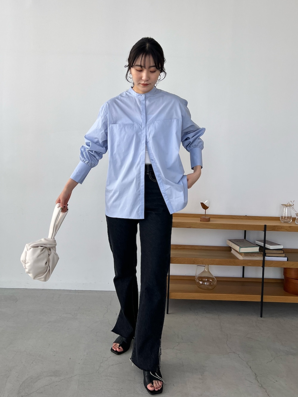 ブルー系のシャツ/ブラウス、ブラック系のデニムパンツ、ホワイト系のハンドバッグを着用したレディースの冬コーディネートの2枚目の写真