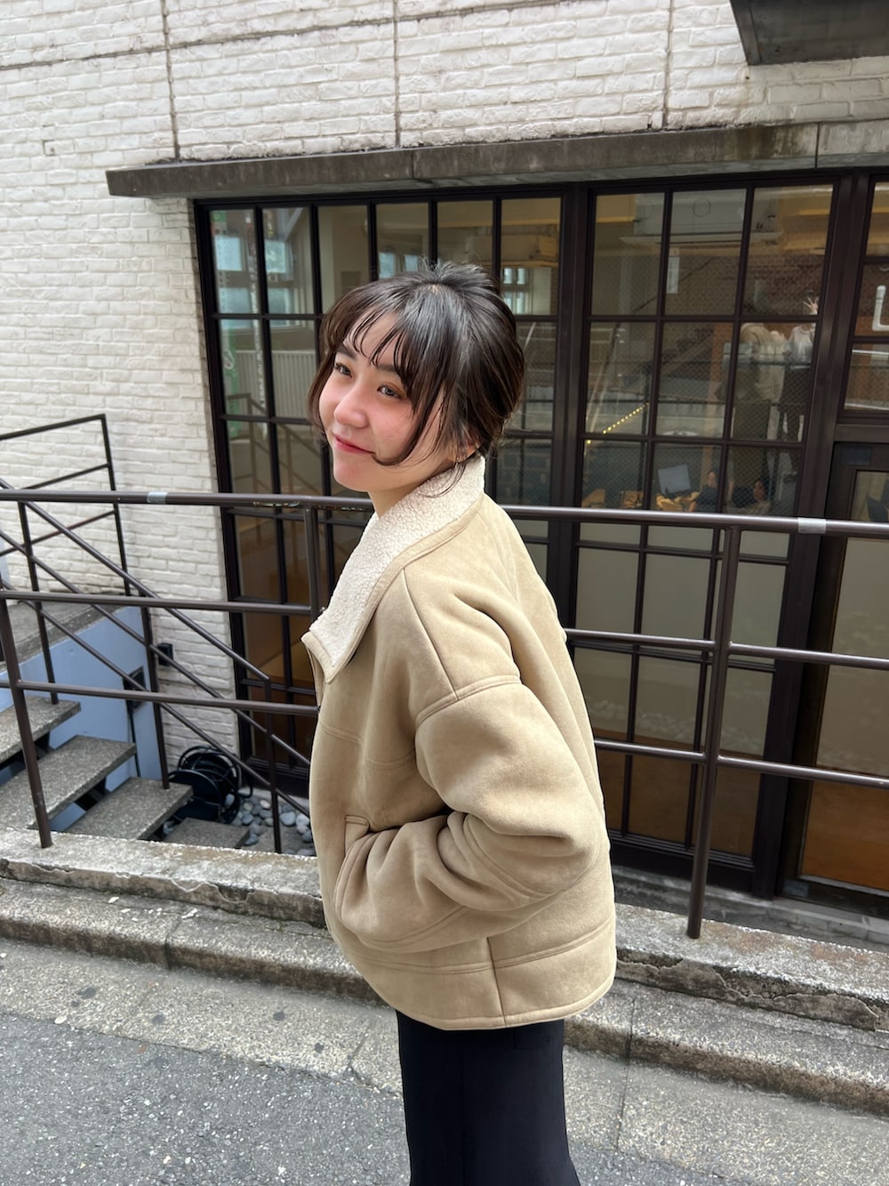 ブラック系のスカート、ホワイト系のTシャツ/カットソー、ベージュ系のその他アウターを着用したレディースの秋コーディネートの2枚目の写真