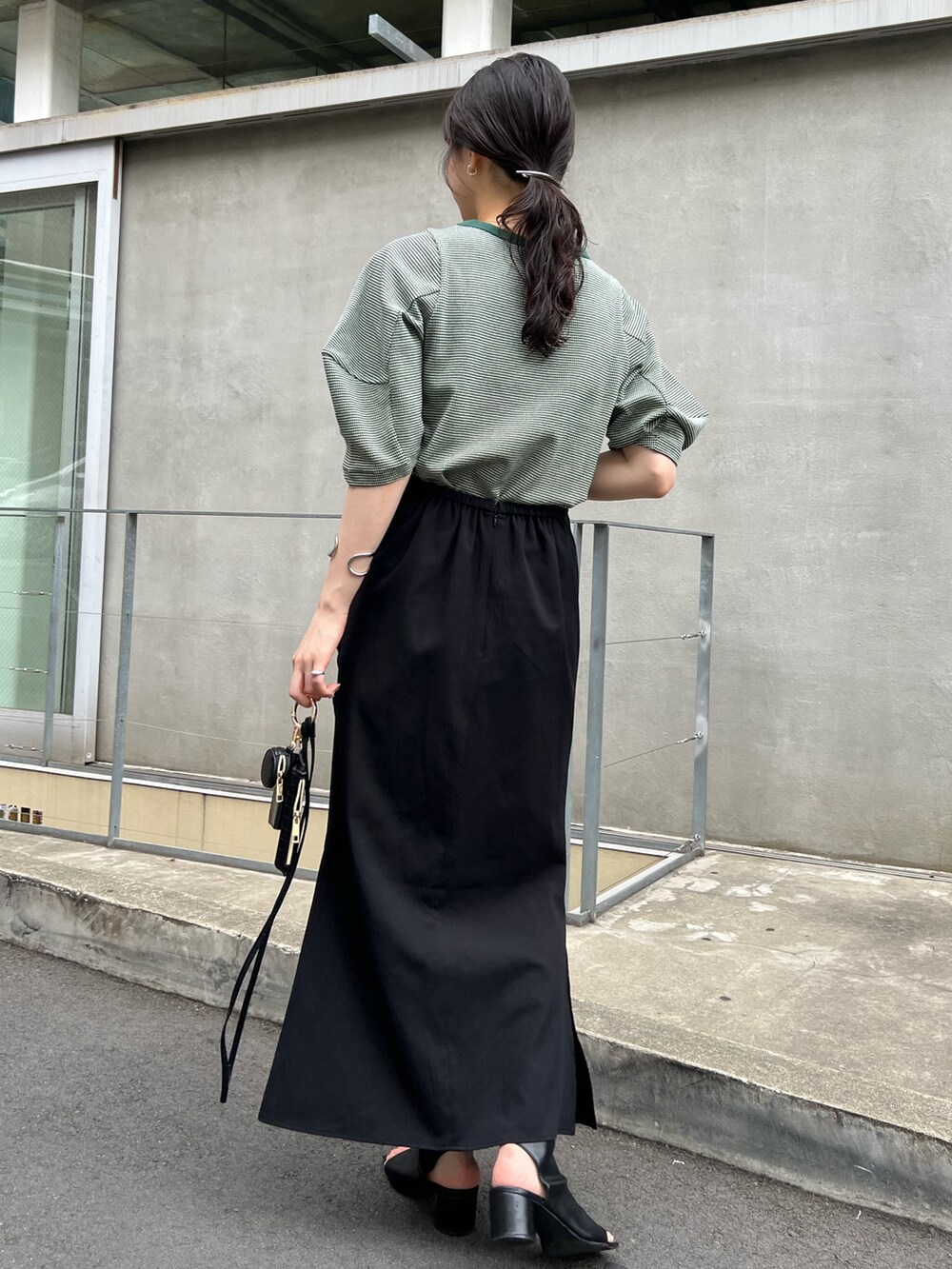グリーン系のTシャツ/カットソー、ブラック系のスカートを着用したレディースの夏コーディネートの3枚目の写真