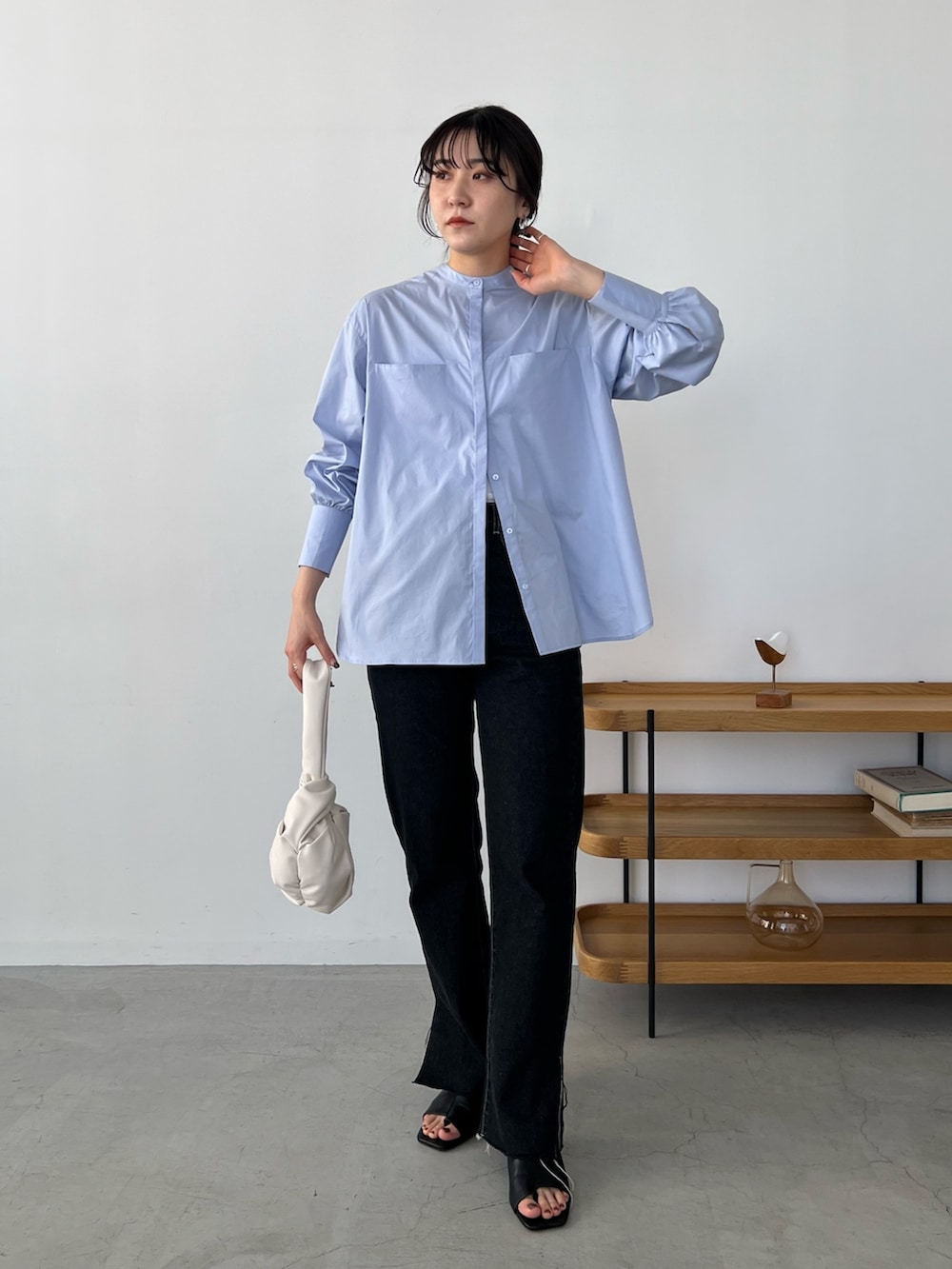 ブルー系のシャツ/ブラウス、ブラック系のデニムパンツ、ホワイト系のハンドバッグを着用したレディースの冬コーディネートの4枚目の写真