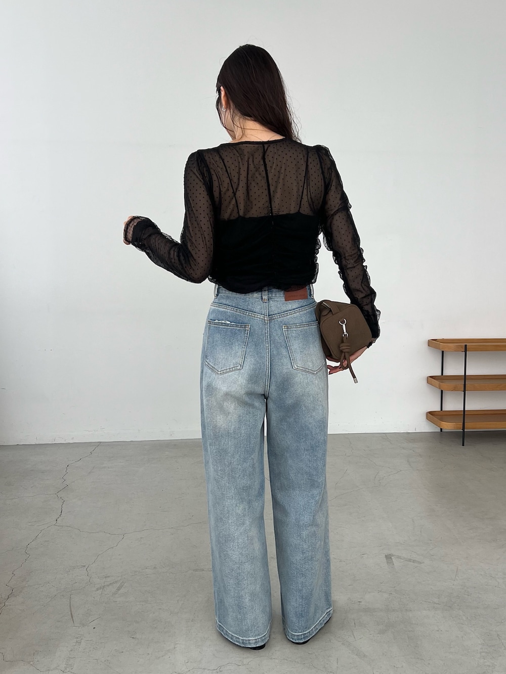 ブルー系のデニムパンツ、ブラック系のシャツ/ブラウス、ブラック系のパンプスを着用したレディースの秋コーディネートの4枚目の写真