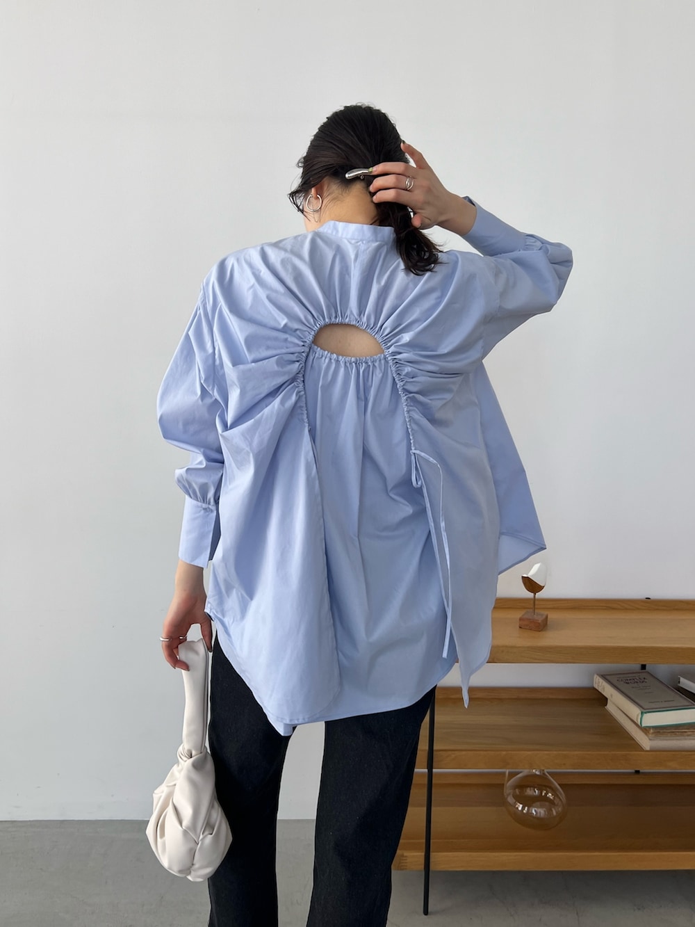 ブルー系のシャツ/ブラウス、ブラック系のデニムパンツ、ホワイト系のハンドバッグを着用したレディースの冬コーディネートの6枚目の写真