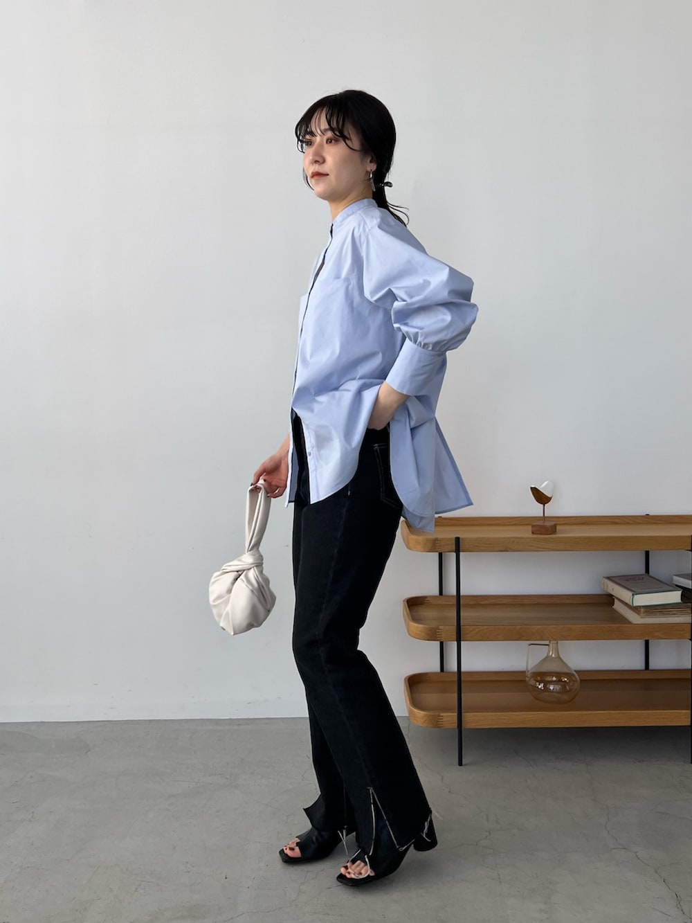 ブルー系のシャツ/ブラウス、ブラック系のデニムパンツ、ホワイト系のハンドバッグを着用したレディースの冬コーディネートの5枚目の写真