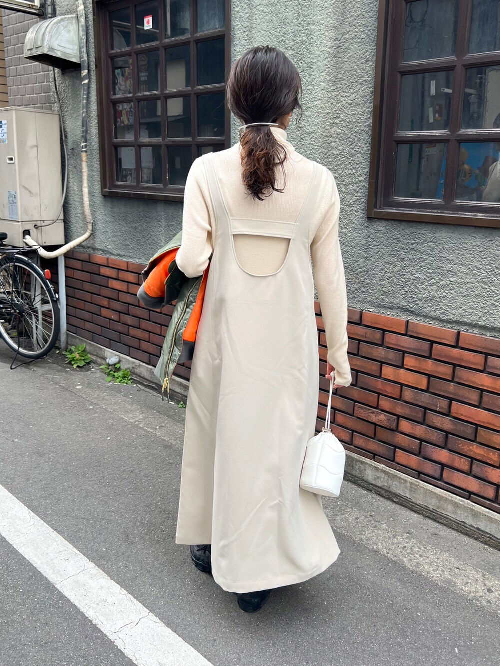 ホワイト系のワンピース、グリーン系のベスト、ホワイト系のニット/セーターを着用したレディースの冬コーディネートの2枚目の写真