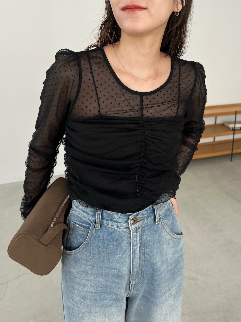 ブルー系のデニムパンツ、ブラック系のシャツ/ブラウス、ブラック系のパンプスを着用したレディースの秋コーディネートの5枚目の写真