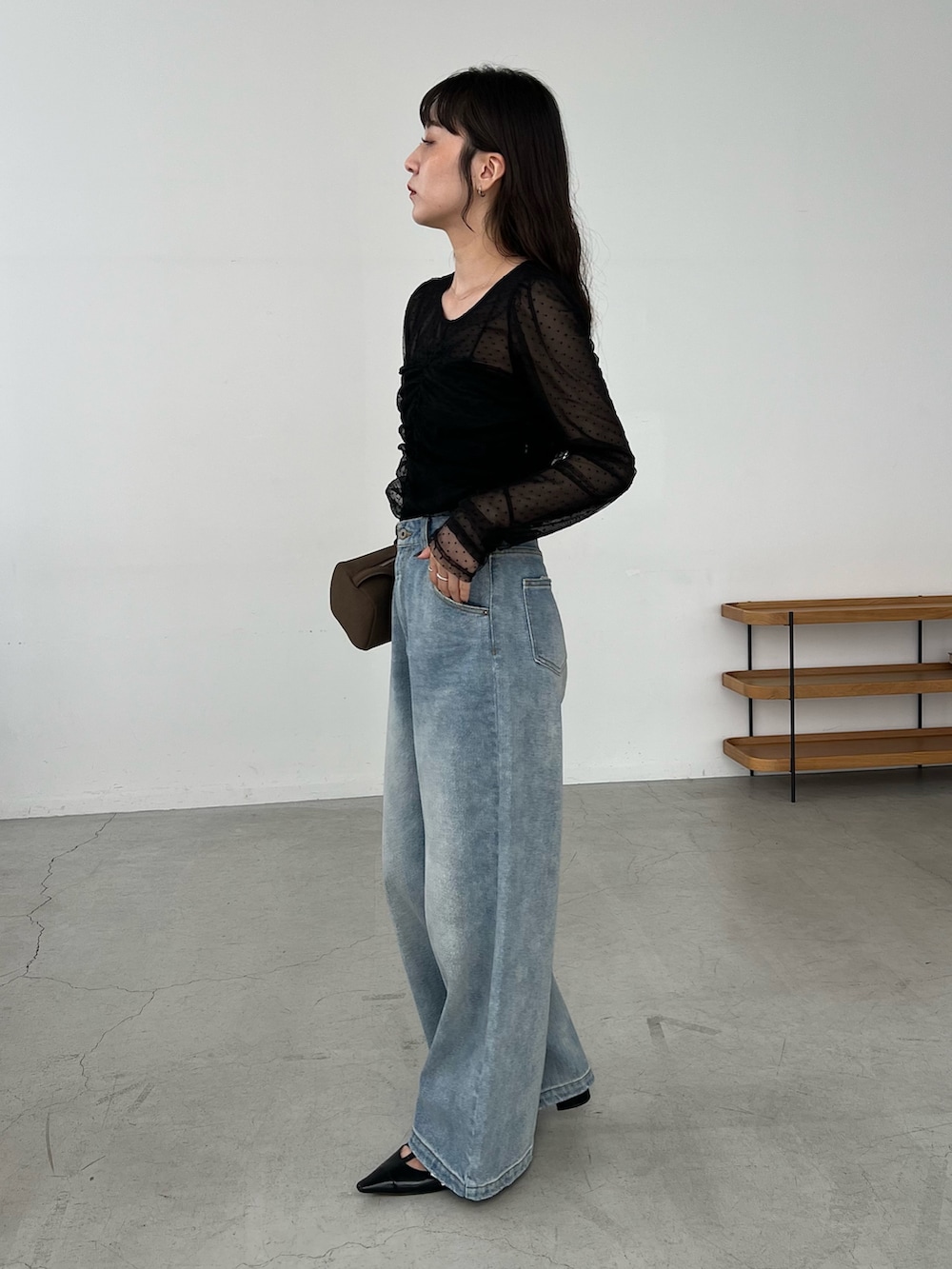 ブルー系のデニムパンツ、ブラック系のシャツ/ブラウス、ブラック系のパンプスを着用したレディースの秋コーディネートの3枚目の写真