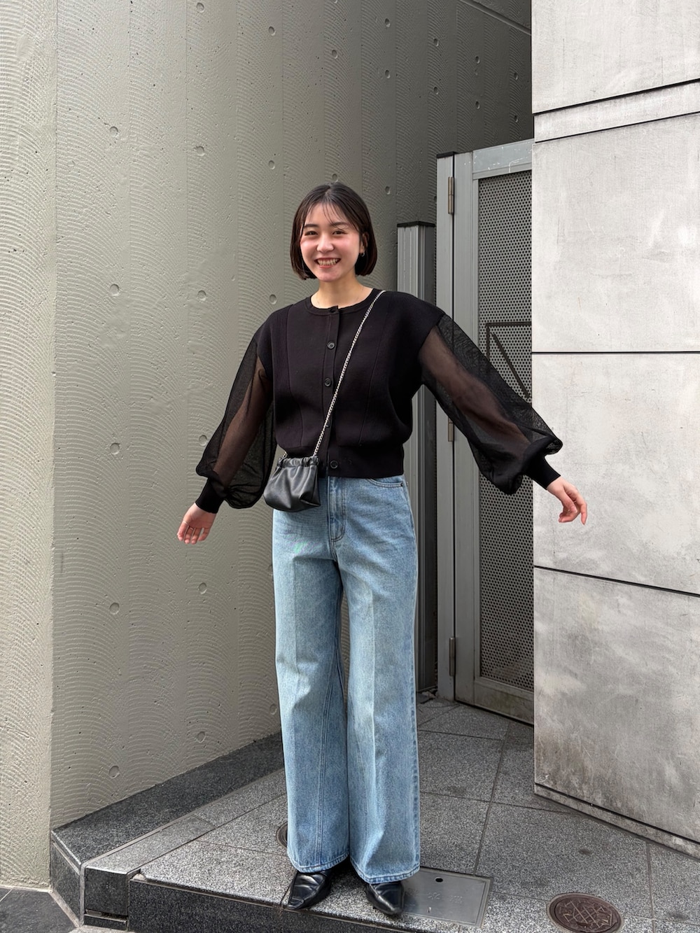 ブラック系のカーディガン/ボレロ、ブルー系のデニムパンツ、ブラック系のローファーを着用したレディースの冬コーディネートの4枚目の写真