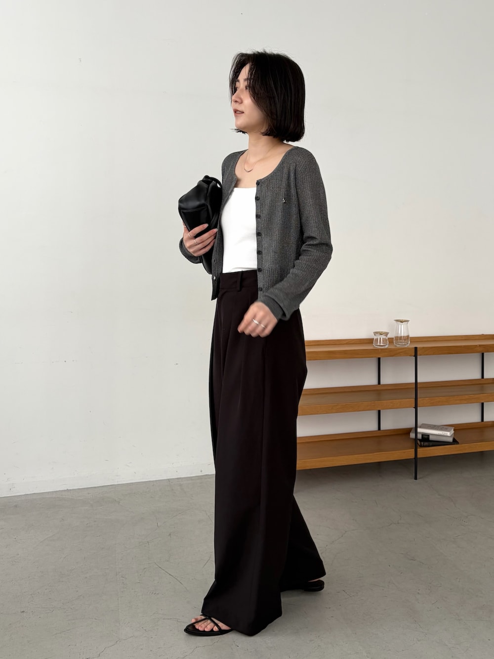 ブラック系のその他パンツ、ブラック系のショルダーバッグ、ホワイト系のキャミソールを着用したレディースの夏コーディネートの2枚目の写真
