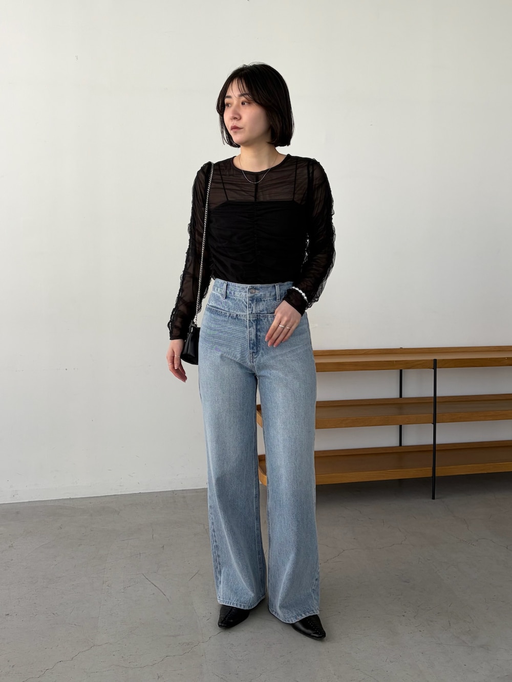 ブルー系のデニムパンツ、ブラック系のシャツ/ブラウス、ブラック系のショルダーバッグを着用したレディースの春コーディネートの3枚目の写真