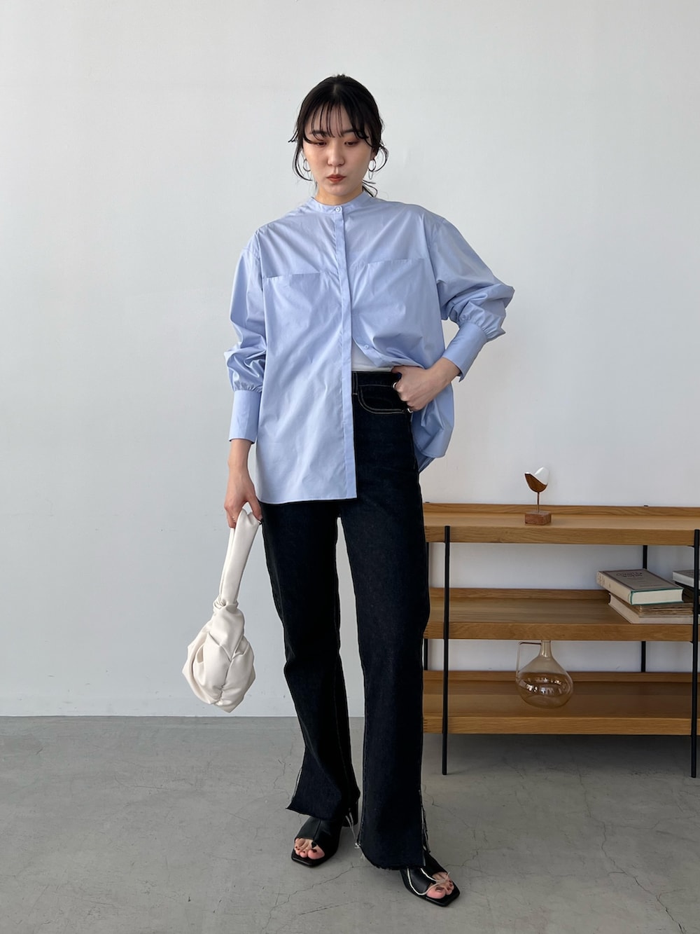 ブルー系のシャツ/ブラウス、ブラック系のデニムパンツ、ホワイト系のハンドバッグを着用したレディースの冬コーディネートの3枚目の写真