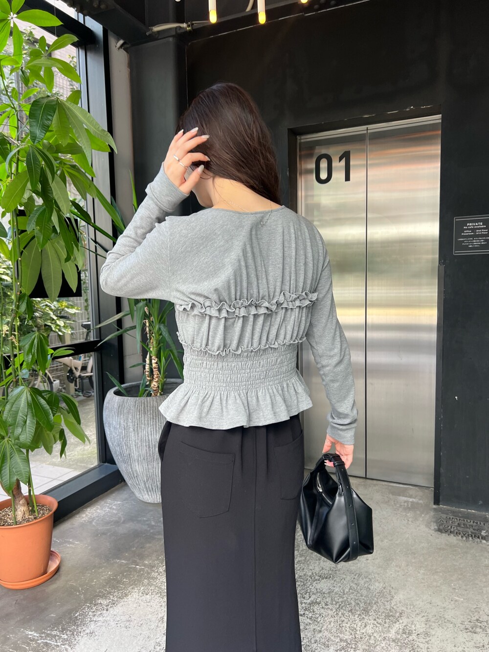 グレー系のTシャツ/カットソー、ブラック系のショルダーバッグ、ブラック系のスカートを着用したレディースの秋コーディネートの4枚目の写真