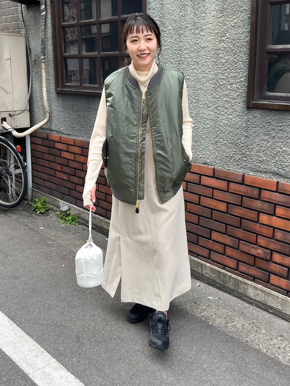 ホワイト系のワンピース、グリーン系のベスト、ホワイト系のニット/セーターを着用したレディースの冬コーディネートの3枚目の写真