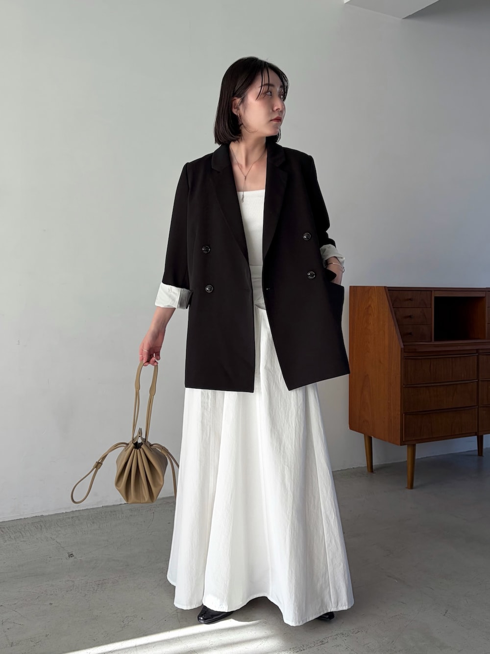 ホワイト系のスカート、ブラック系のテーラードジャケットを着用したレディースの冬コーディネートの4枚目の写真