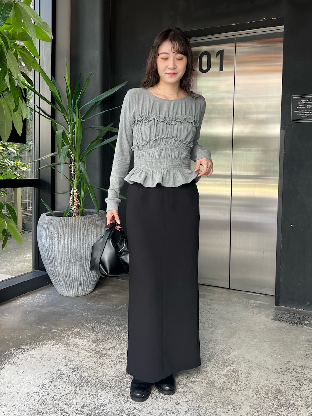 グレー系のTシャツ/カットソー、ブラック系のショルダーバッグ、ブラック系のスカートを着用したレディースの秋コーディネートの2枚目の写真