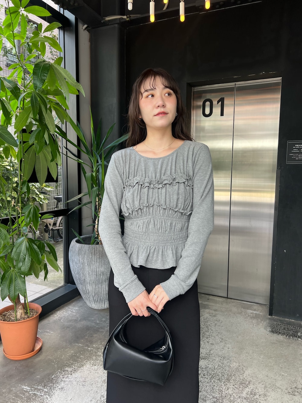 グレー系のTシャツ/カットソー、ブラック系のショルダーバッグ、ブラック系のスカートを着用したレディースの秋コーディネートの3枚目の写真