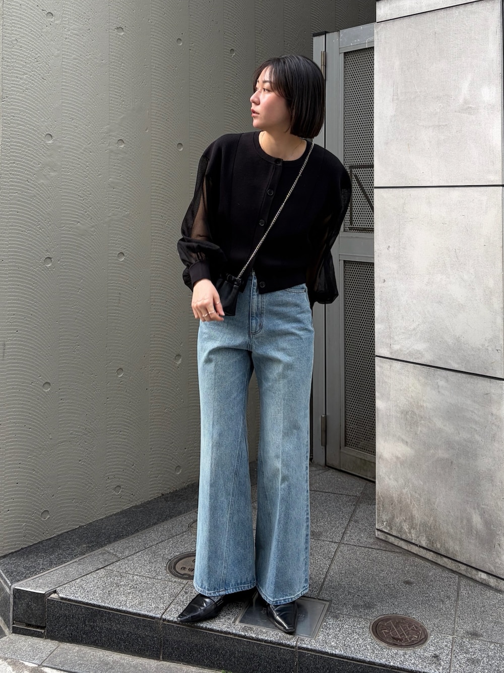 ブラック系のカーディガン/ボレロ、ブルー系のデニムパンツ、ブラック系のローファーを着用したレディースの冬コーディネートの3枚目の写真