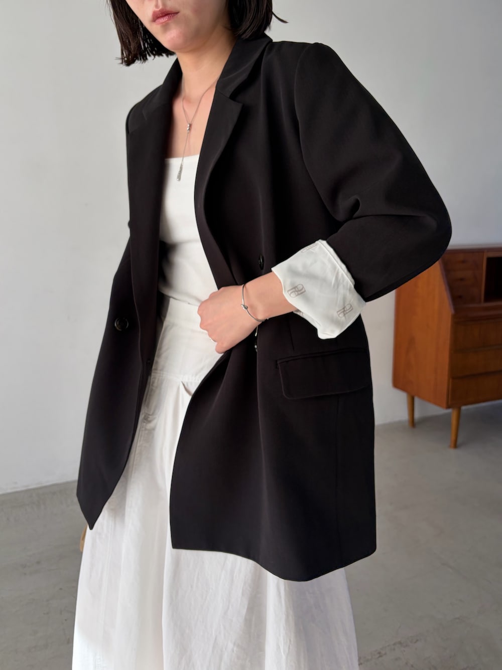 ホワイト系のスカート、ブラック系のテーラードジャケットを着用したレディースの冬コーディネートの3枚目の写真