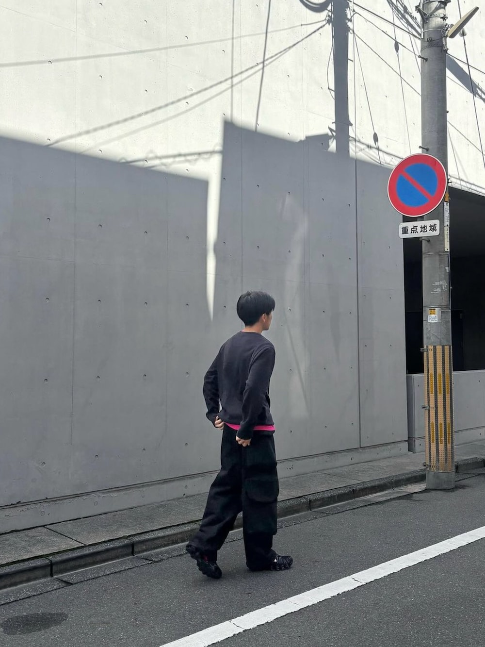 ブラック系のカーゴパンツ、ブラック系のスニーカーを着用したメンズの秋コーディネートの2枚目の写真