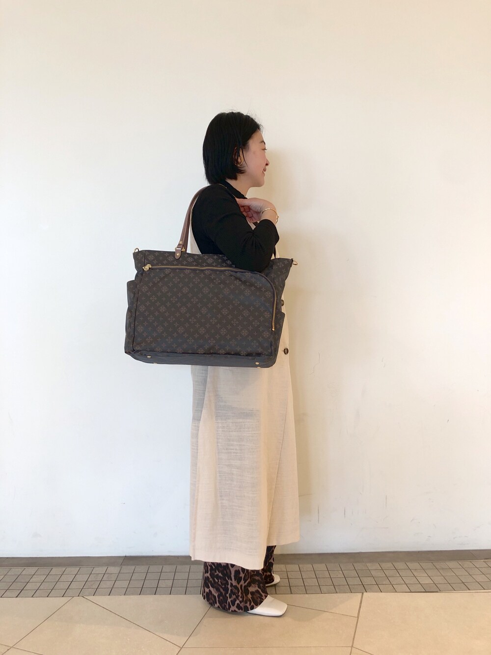 グレー系のトートバッグ、その他のパンツ、ホワイト系のパンプスを着用したレディースの冬コーディネートの4枚目の写真
