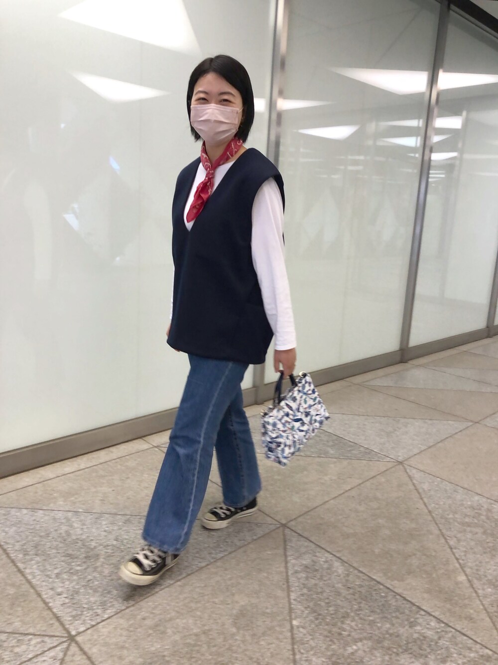 ブルー系のベスト、ブルー系のショルダーバッグを着用したレディースの春コーディネートの2枚目の写真