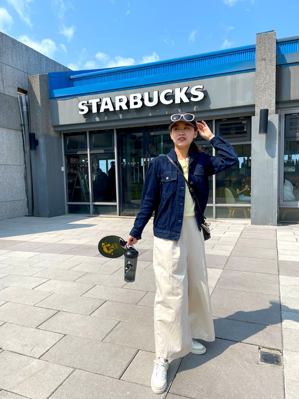 ブルー系のジャケット/アウター、イエロー系のTシャツ/カットソー、ベージュ系のその他パンツを着用したレディースの春コーディネートの2枚目の写真