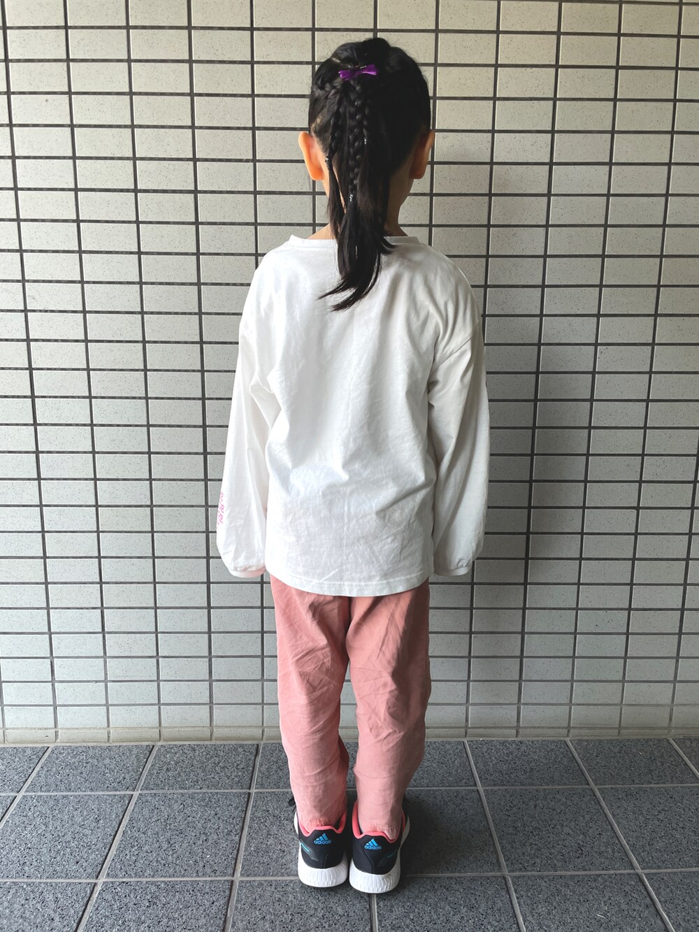 ピンク系のパンツ、ブラック系のスニーカー、ホワイト系のTシャツ/カットソーを着用したキッズの秋コーディネートの2枚目の写真
