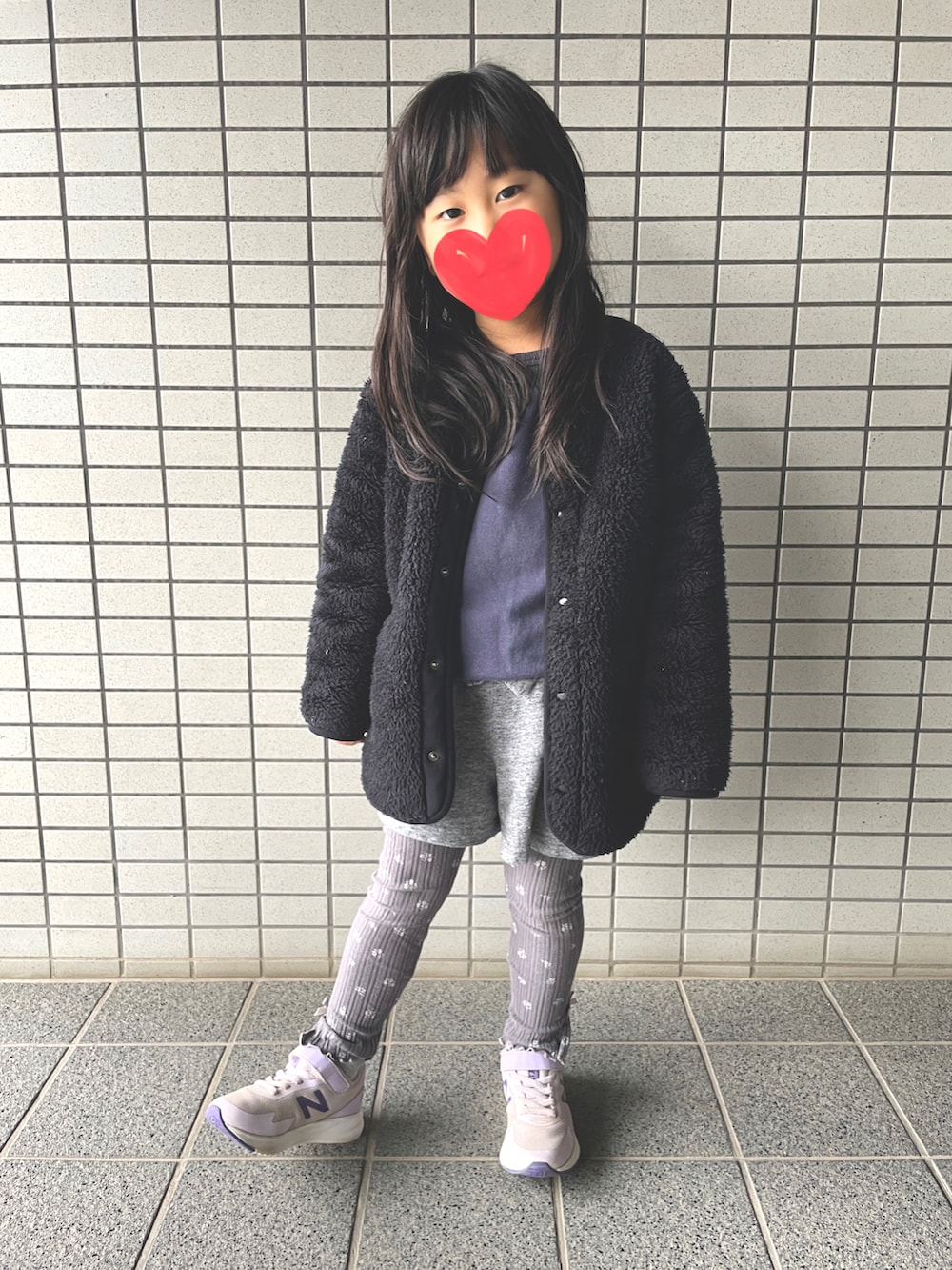 ブルー系のスウェット、グレー系のスカート、ブラック系のノーカラーコートを着用したキッズの春コーディネートの2枚目の写真