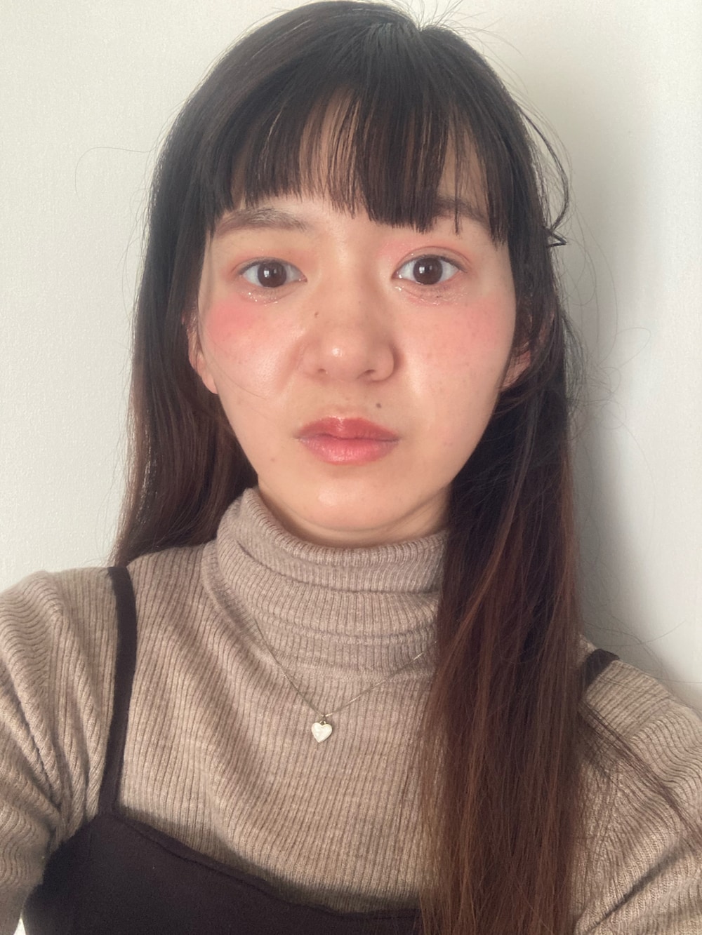 ピンク系のトップスを着用したレディースの冬コーディネートの2枚目の写真