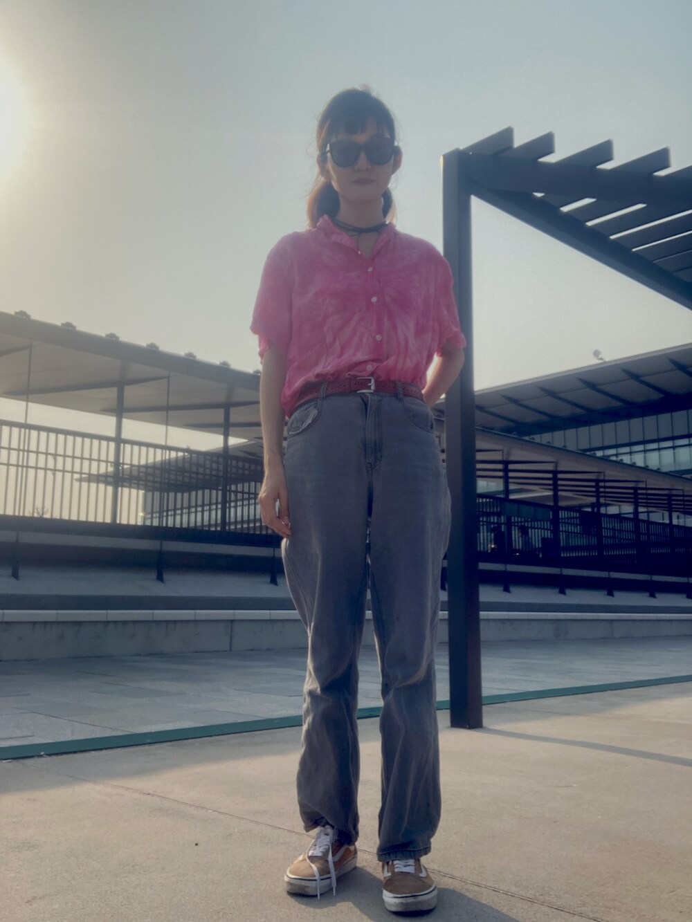 ブルー系のデニムパンツ、ピンク系のTシャツ/カットソー、ブラック系のメガネを着用したレディースの春コーディネートの2枚目の写真