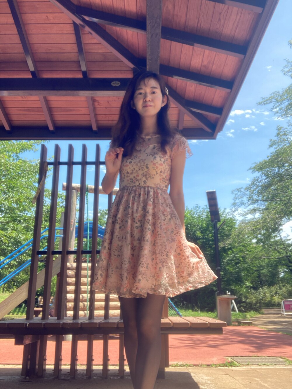 ピンク系のワンピースを着用したレディースの夏コーディネートの2枚目の写真