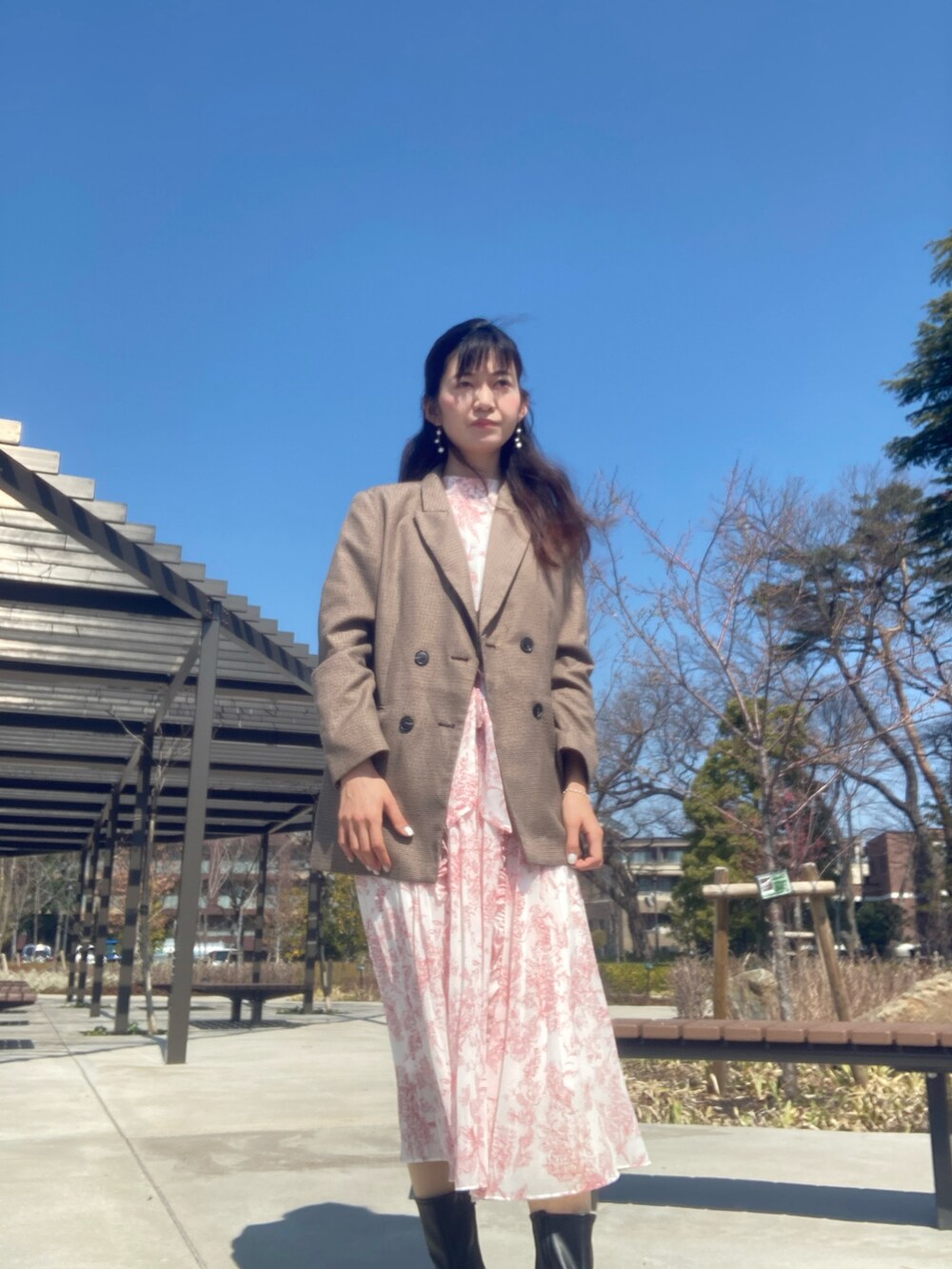 ピンク系のワンピースを着用したレディースの春コーディネートの2枚目の写真