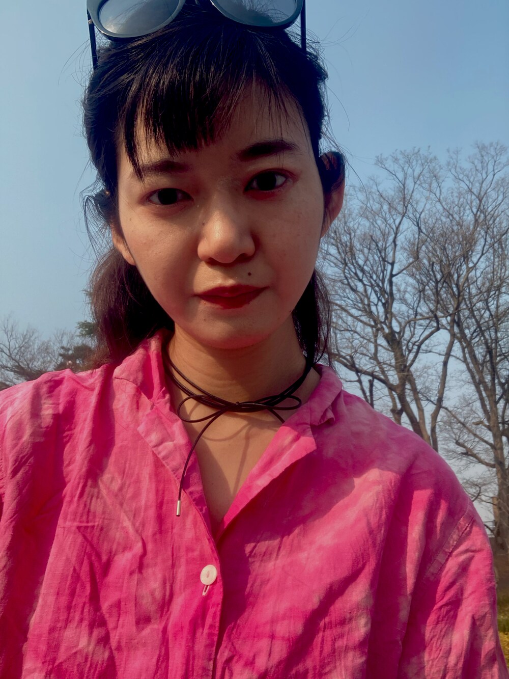 ブルー系のデニムパンツ、ピンク系のTシャツ/カットソー、ブラック系のメガネを着用したレディースの春コーディネートの3枚目の写真