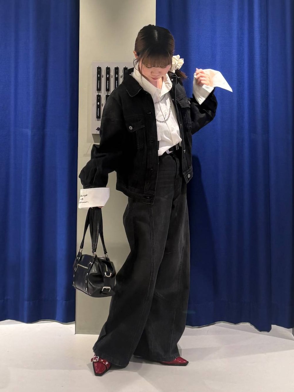 ブラック系のショルダーバッグ、ブラック系のデニムパンツ、ブラック系のデニムジャケットを着用したレディースの夏コーディネートの2枚目の写真