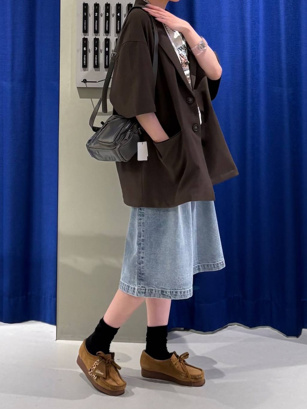ブルー系のデニムパンツ、グレー系のショルダーバッグ、ホワイト系のTシャツ/カットソーを着用したレディースの春コーディネートの2枚目の写真