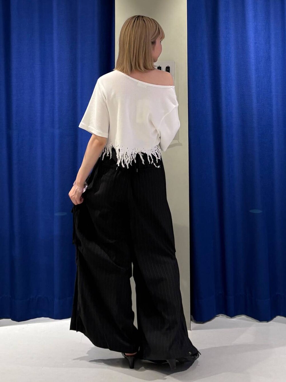 ブラック系のサンダル、ブラック系のカーゴパンツ、ホワイト系のTシャツ/カットソーを着用したレディースの夏コーディネートの4枚目の写真