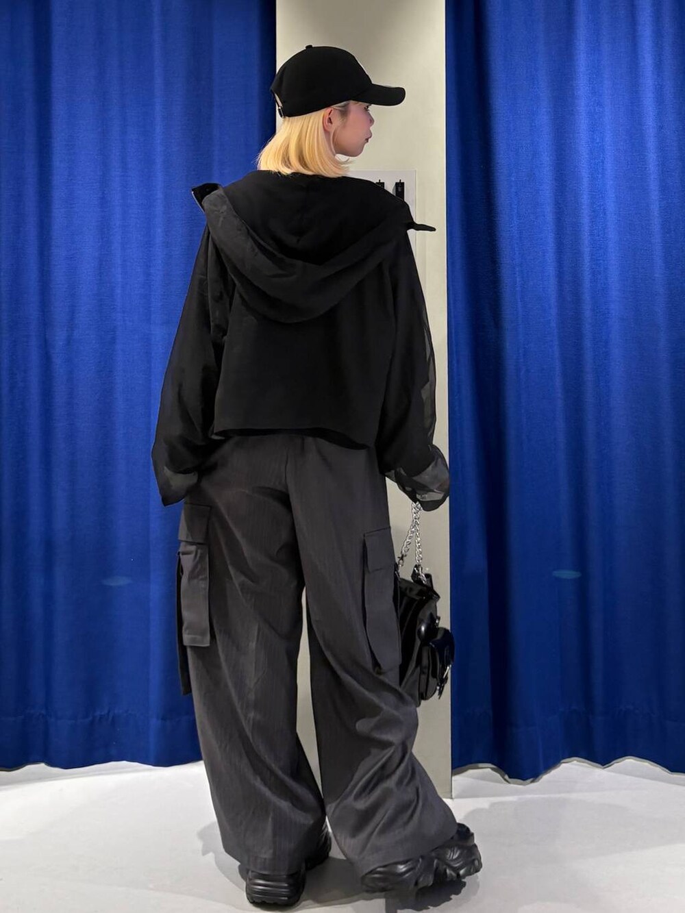 ブラック系のスニーカー、ホワイト系のTシャツ/カットソー、ブラック系のショルダーバッグを着用したレディースの秋コーディネートの3枚目の写真