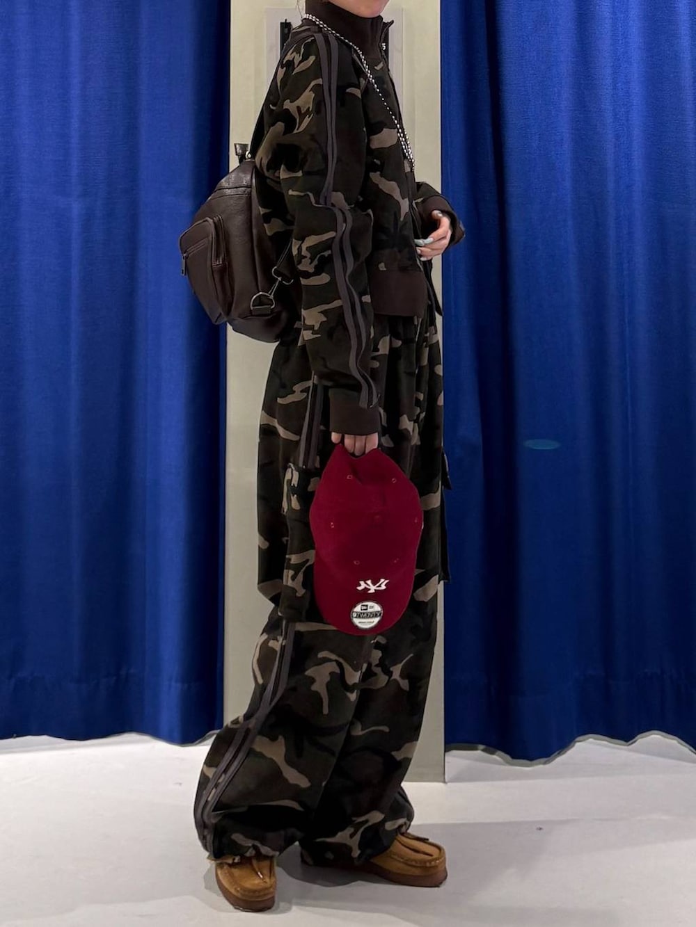 ホワイト系のキャミソール、ブラウン系のショルダーバッグ、グリーン系のジャージを着用したレディースの春コーディネートの2枚目の写真