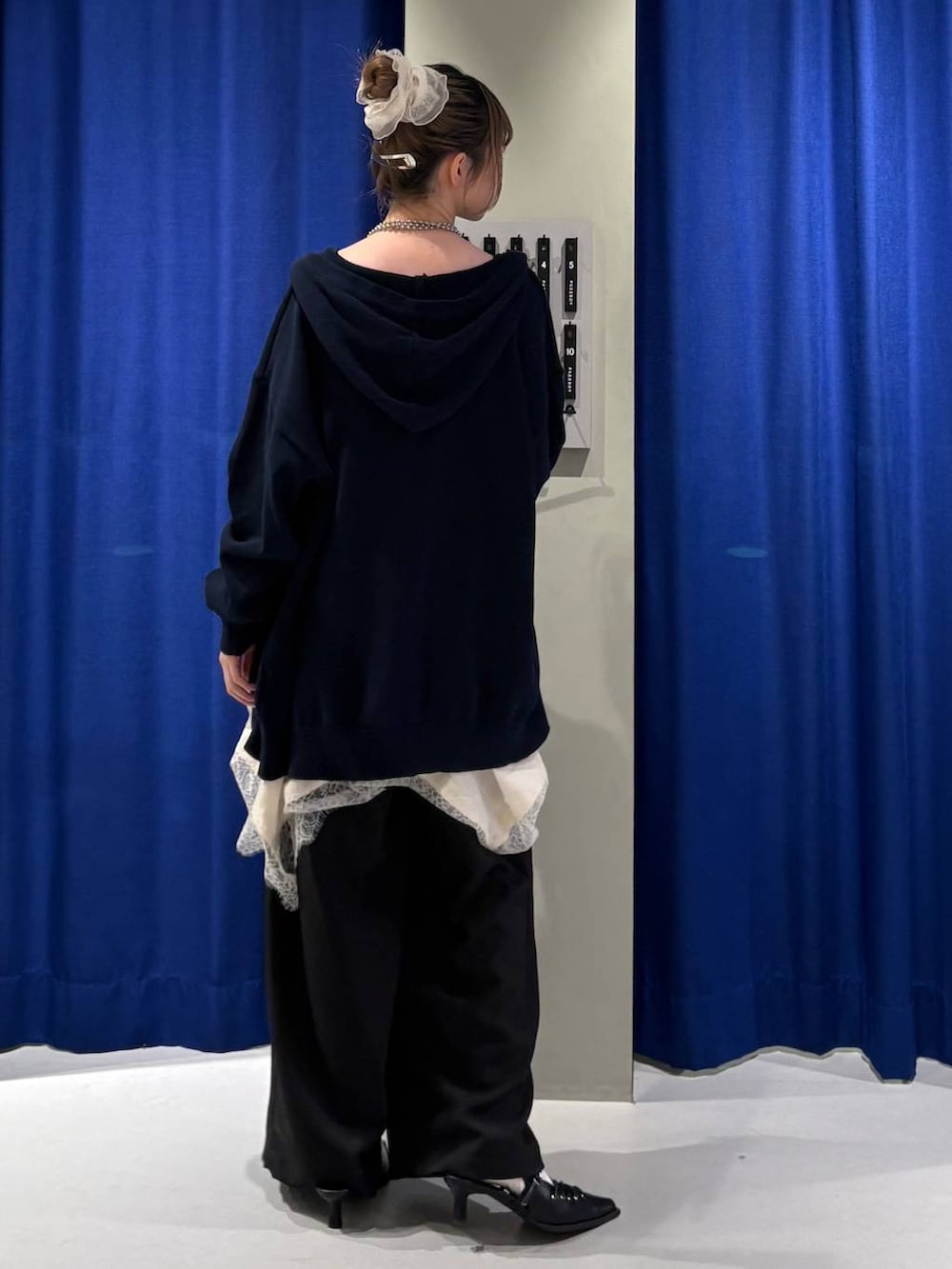 ホワイト系のキャミソール、ブルー系のパーカー、ホワイト系のチュニックを着用したレディースの春コーディネートの3枚目の写真