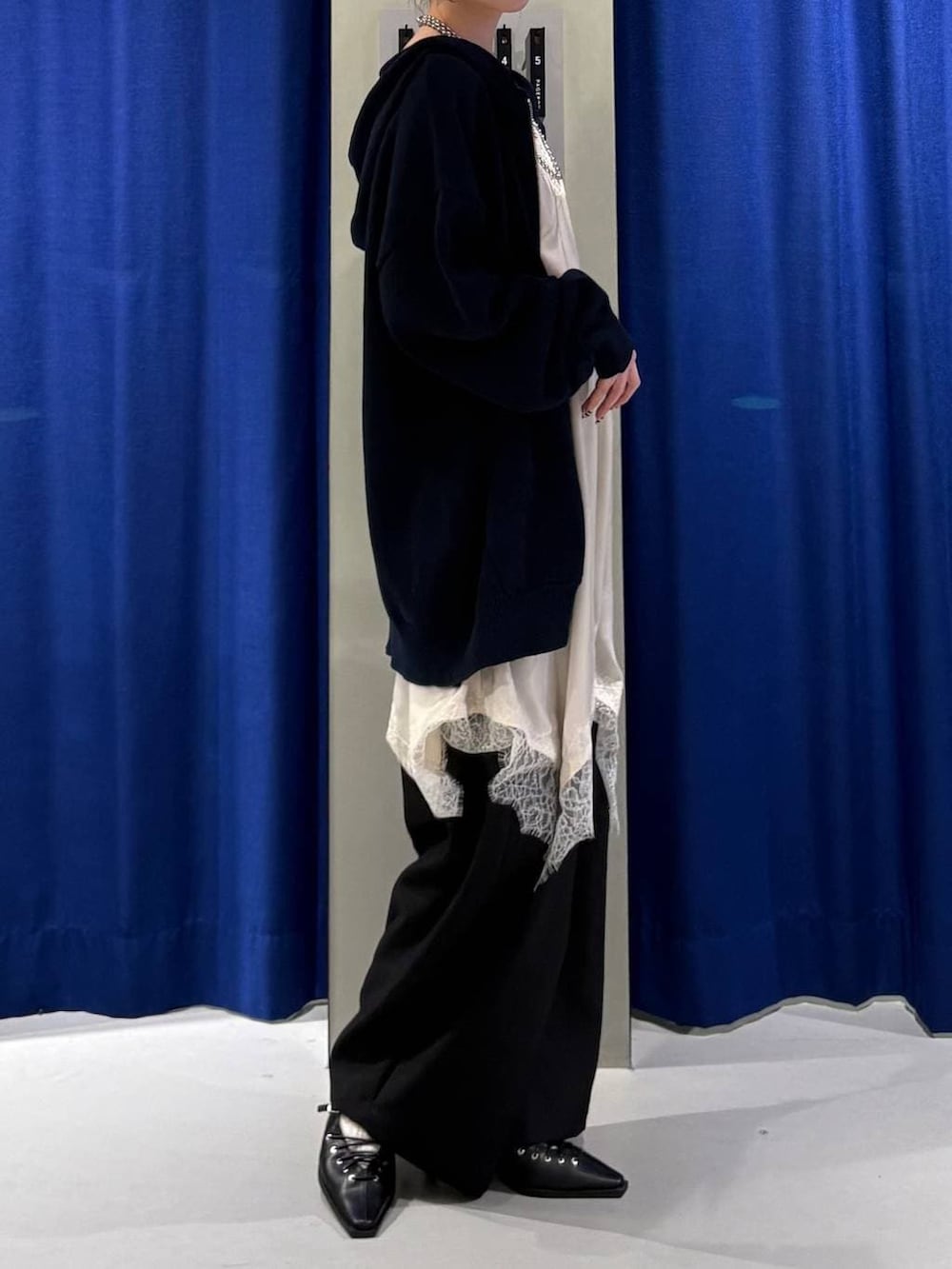 ホワイト系のキャミソール、ブルー系のパーカー、ホワイト系のチュニックを着用したレディースの春コーディネートの2枚目の写真