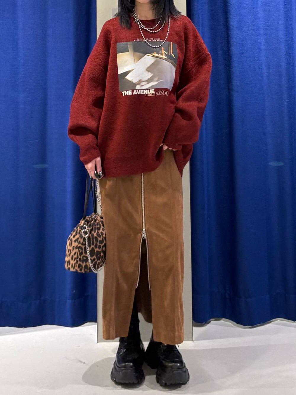 ブラック系のブーツ、ブラック系のハンドバッグ、イエロー系のスカートを着用したレディースの冬コーディネートの2枚目の写真