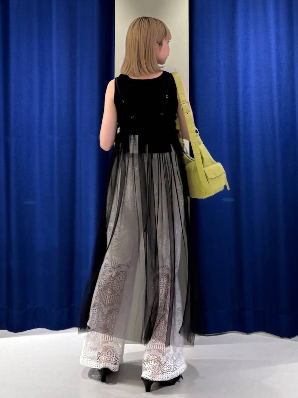 ブラック系のタンクトップ、グリーン系のショルダーバッグ、ブラック系のサンダルを着用したレディースの夏コーディネートの3枚目の写真