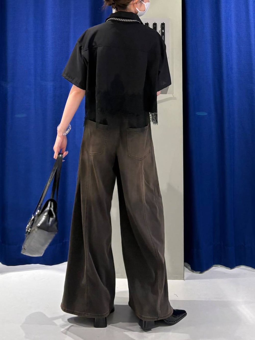 ブラウン系のデニムパンツ、ホワイト系のキャミソール、ブラック系のシャツ/ブラウスを着用したレディースの夏コーディネートの3枚目の写真