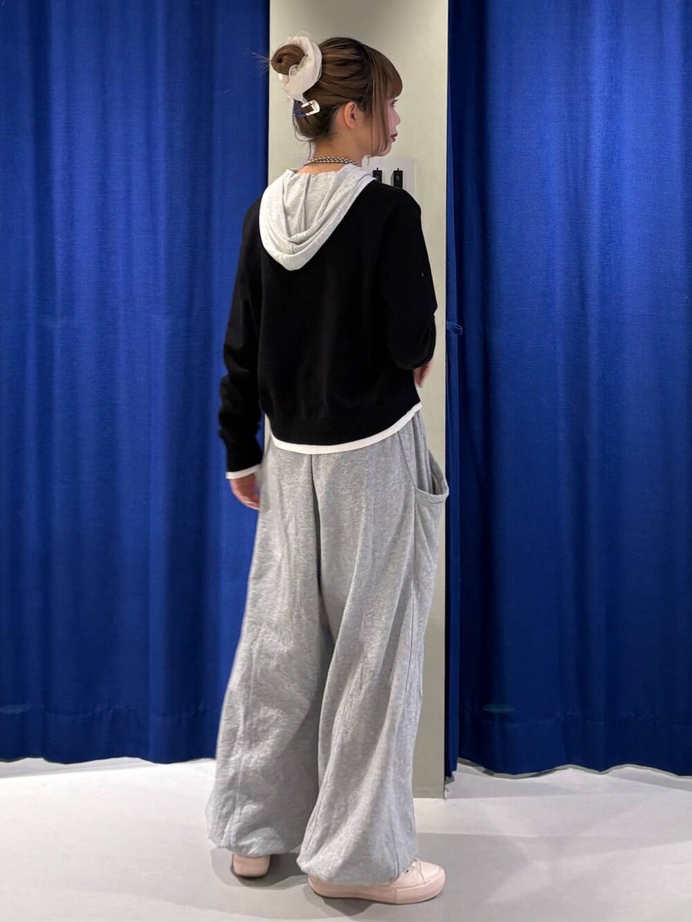 グレー系のスウェットパンツ、ホワイト系のカーディガン/ボレロ、グレー系のTシャツ/カットソーを着用したレディースの冬コーディネートの3枚目の写真