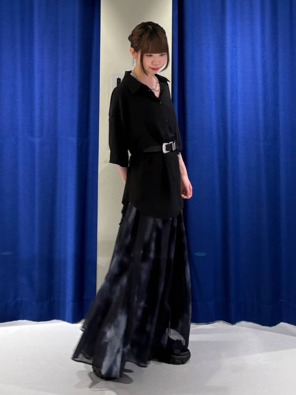 ブラック系のスカート、ブラック系のサンダル、ブラック系のシャツ/ブラウスを着用したレディースの夏コーディネートの2枚目の写真