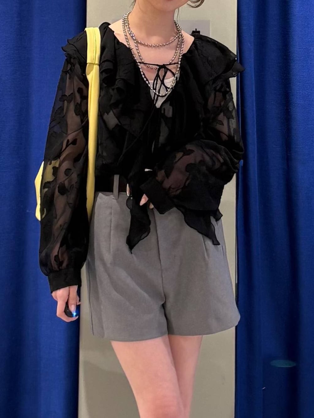 ブラック系のブーツ、ホワイト系のキャミソール、ブラック系のショルダーバッグを着用したレディースの春コーディネートの4枚目の写真