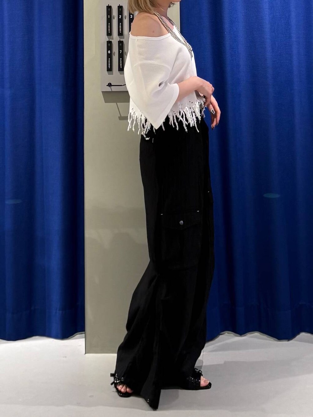 ブラック系のサンダル、ブラック系のカーゴパンツ、ホワイト系のTシャツ/カットソーを着用したレディースの夏コーディネートの3枚目の写真