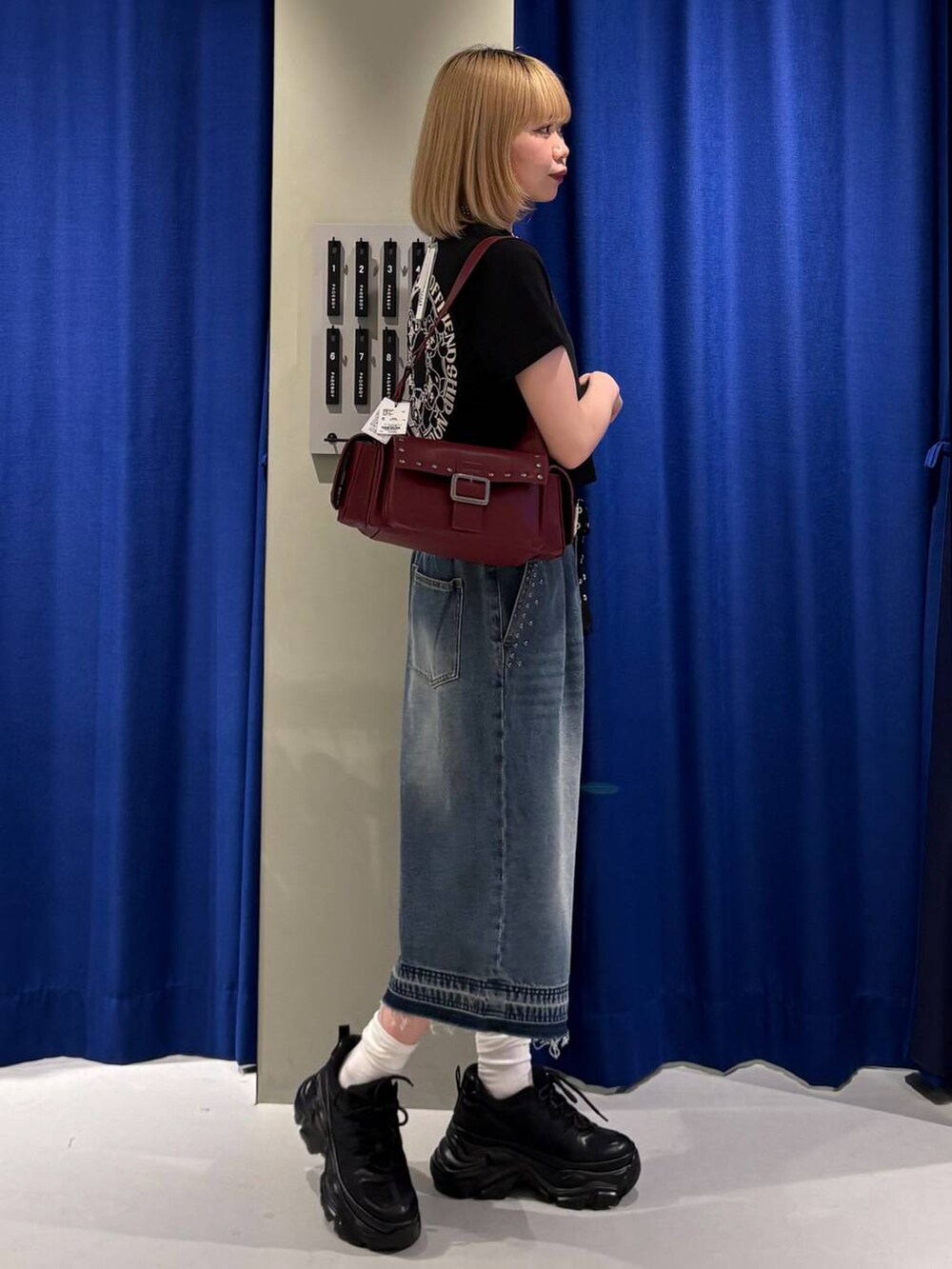 ブラック系のスニーカー、ブラック系のTシャツ/カットソー、ブルー系のデニムパンツを着用したレディースの夏コーディネートの2枚目の写真